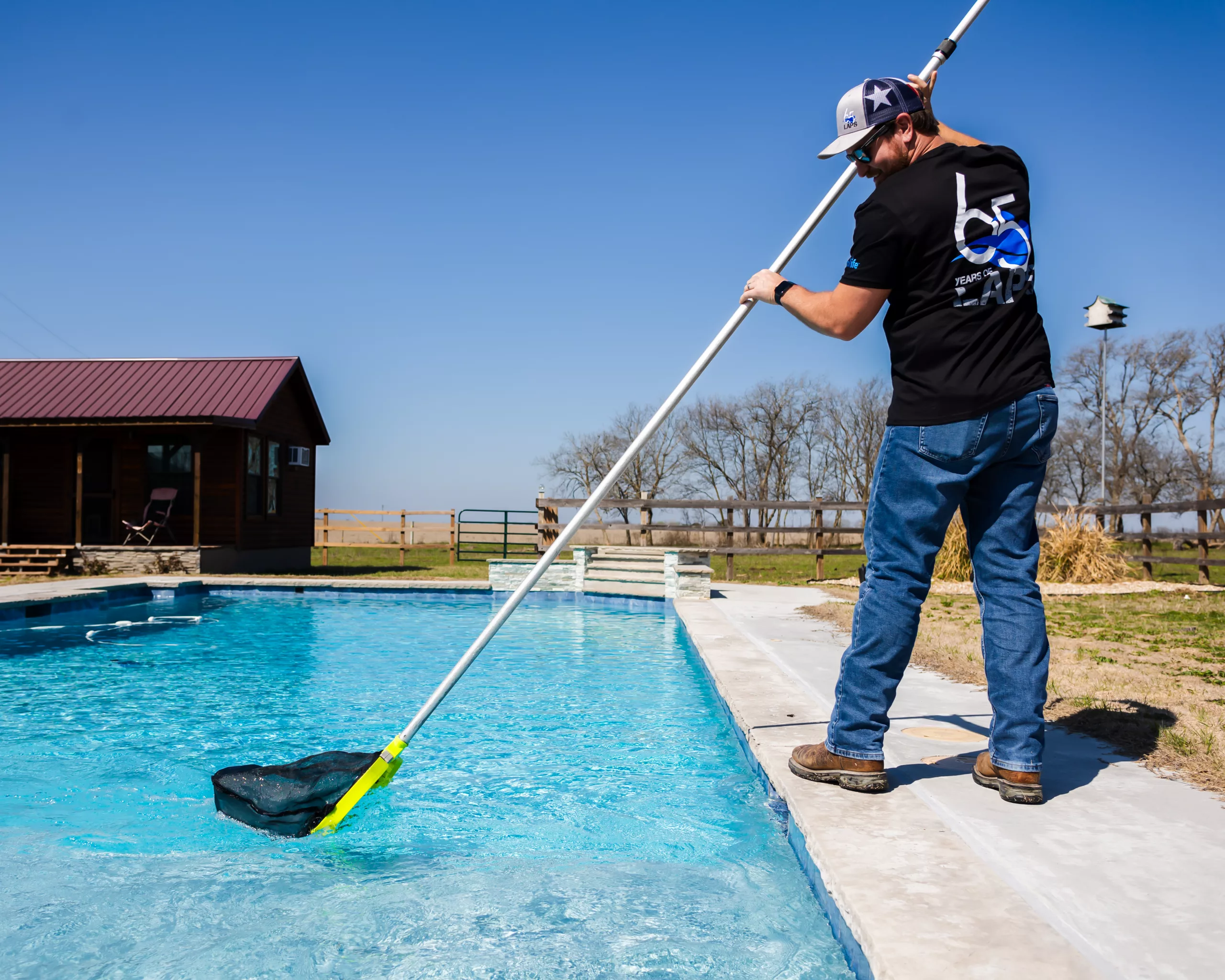 pool service technician cleaning a customer's pool